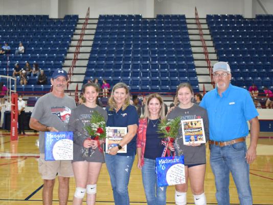 Madisonville volleyball seniors Maegan Anderson and Mackenzie Foster pose with their families at MHS Friday on senior night. CAMPBELL ATKINS
