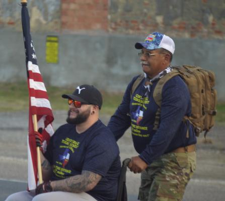 A Veteran with the nickname Hawk holding the American Flag as he and Eric Munoz start the walk to Madisonville from Centerville. PHOTO BY RICHARD SIRMAN