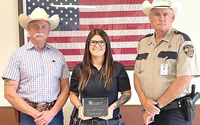 Madison County Sheriff Investigator Carly Foster stands with Chief Deputy Curtis Klingle (left) and Sheriff Bobby Adams (right) after being awarded the 2022 Texas Humane Advocate Award.