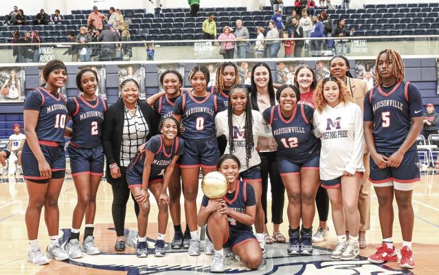 From left to right, Olyvia Brooks, Quin’neysia Shaffer, Tarsha Nealey, Keilee Green, Khia Byrd, Shemia Morning, Tyona Lewis, Ke’miya Dunn, Bre’anda Moffett, Karly Leamon, Zeaira Carter, Brisa McCloud, Laneique Nealey, Ke’myreul Wheaton. Players and coaches of the Madisonville Lady Mustangs Varsity basketball team after their win against Connally on Friday, Feb. 23. METEOR PHOTO BY JAY HARDY