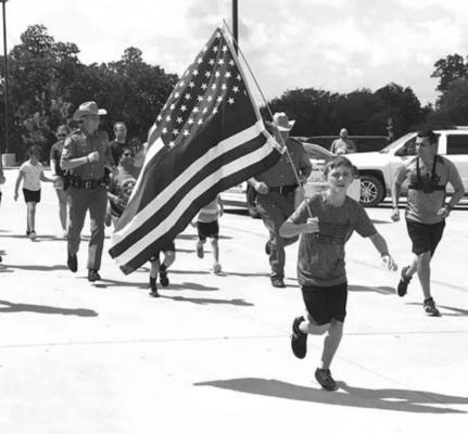 12-year-old Zechariah Cartledge of Running 4 Heroes prepares to lead a group of runners at Madisonville High School Saturday in honor of First Responders. PHOTO BY CAMPBELL ATKINS